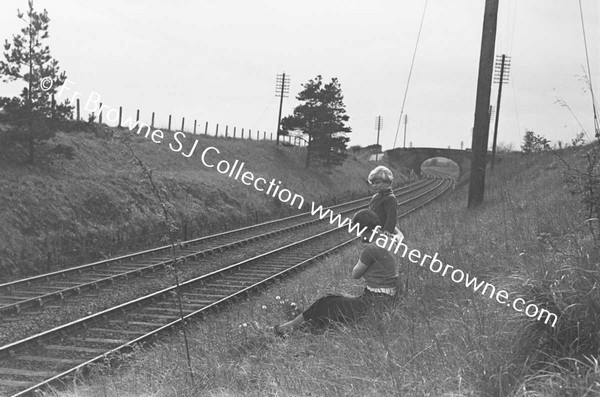 BOYS WATCHING AND WAITING AT RAILWAY EMBANKMENT